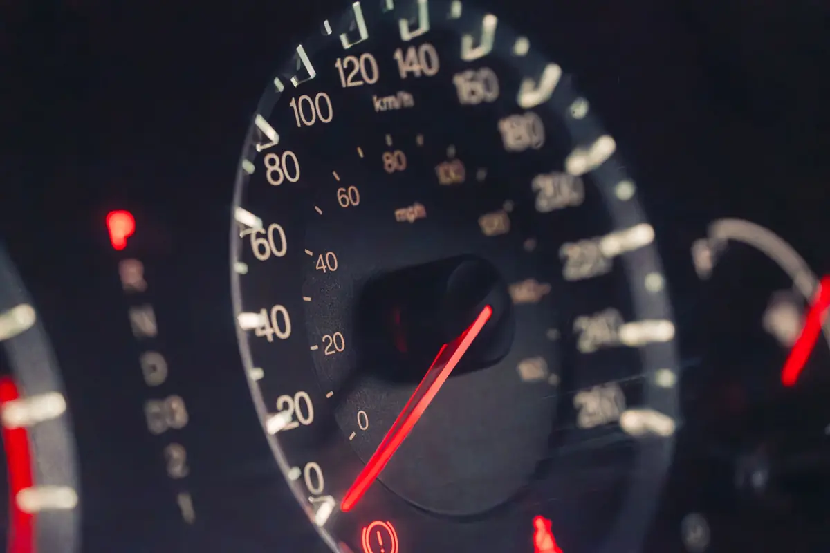 Compteur de vitesse d'une voiture en éclairage nocturne, aiguille en mouvement