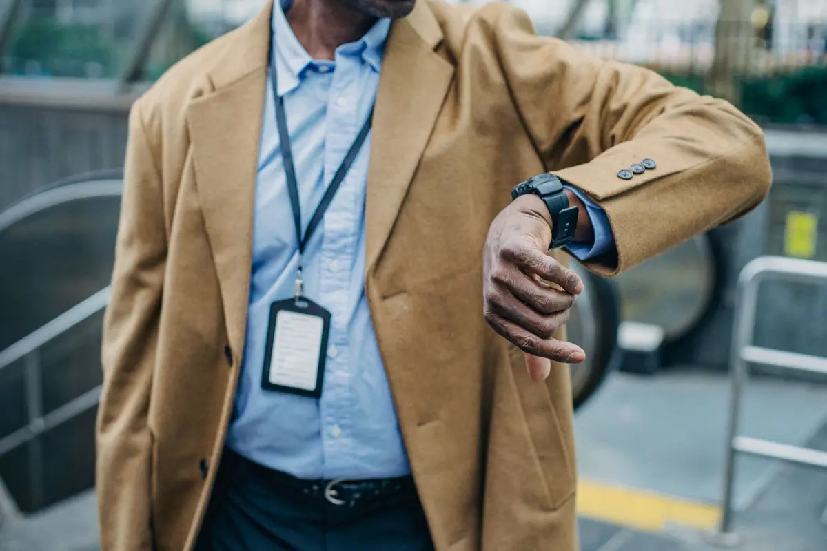 Homme pressé consultant sa montre dans la rue